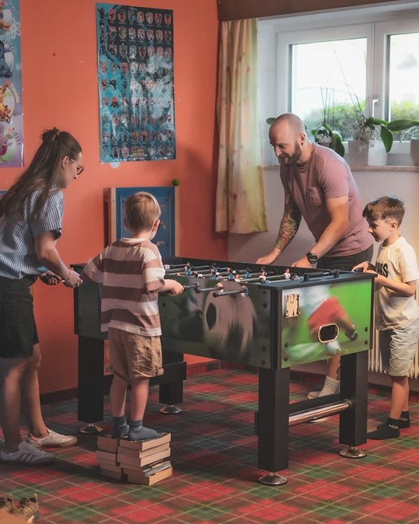 Spielen im Spielzimmer beim Tischfu&szlig;ball mit Mama und Papa