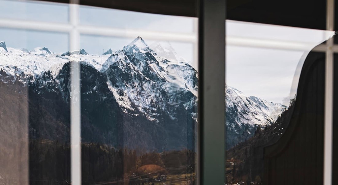 Schneebedecktes Kitzsteinhorn spiegeln sich in einem Fenster