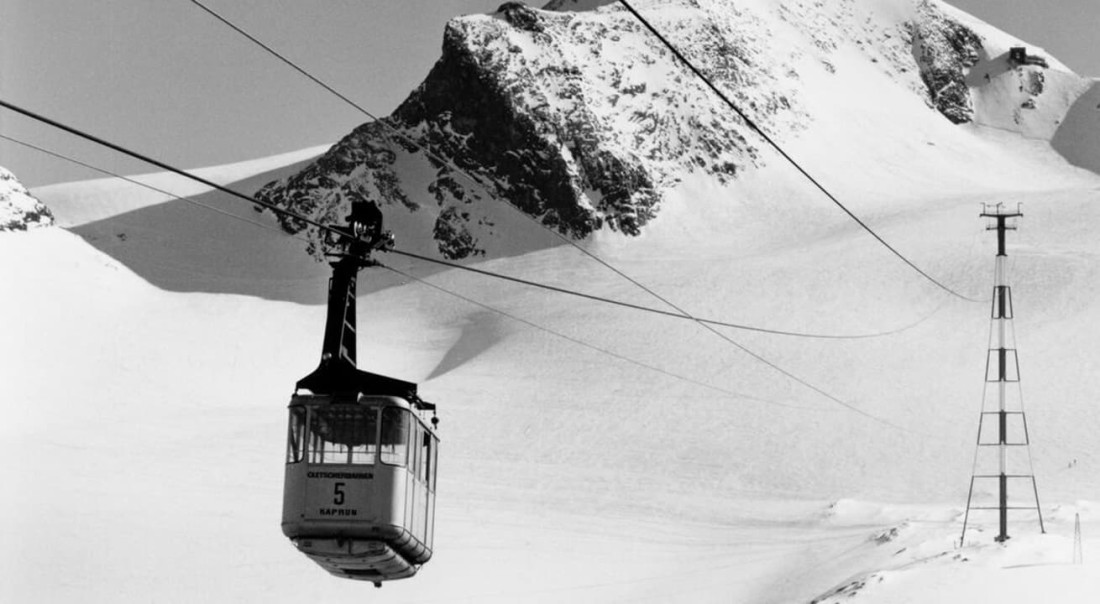 Alte Seilbahn f&auml;hrt vor schneebedeckten Bergen im Gletscherskigebiet am Kitzsteinhorn