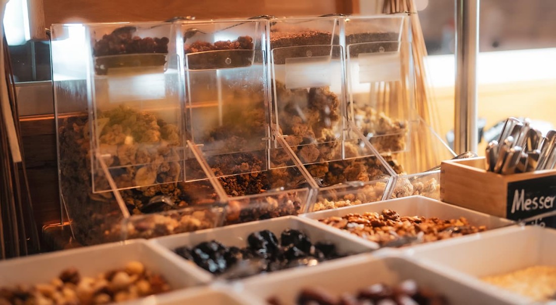 Verschiedene Beh&auml;lter mit M&uuml;sli und Schalen mit N&uuml;ssen am Fr&uuml;hst&uuml;cksbuffet im Hotel Kaprunerhof
