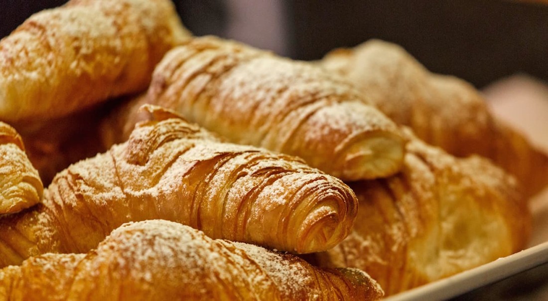 Frisch gebackene Croissants mit Puderzucker best&auml;ubt