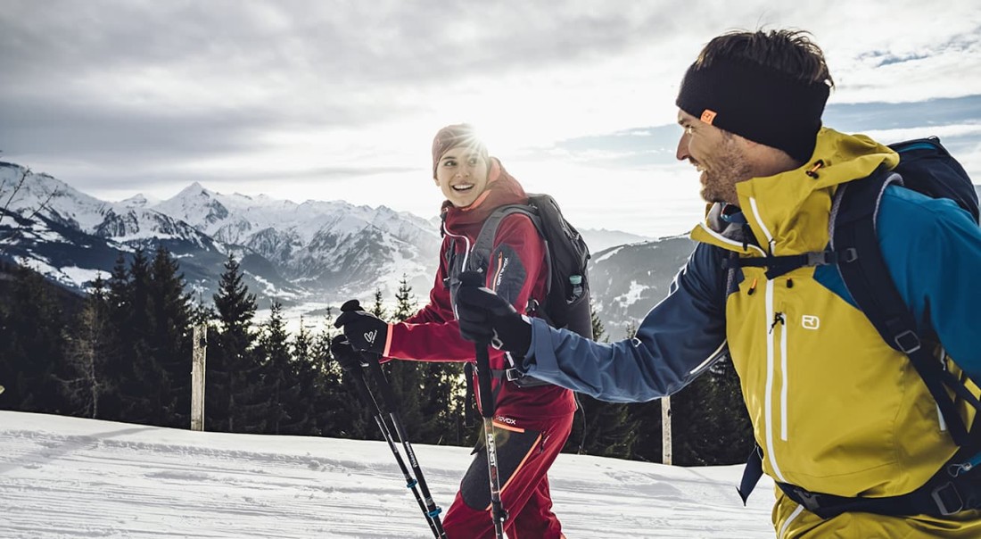 Zwei Personen beim Winterwandern in bergiger Schneelandschaft in der Region Zell am See-Kaprun