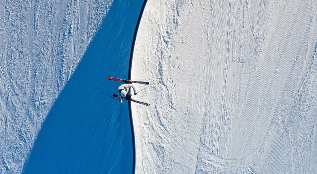 Eine Skifahrerin im Gletscherskigebiet am Kitzsteinhorn  f&uuml;hrt einen Trick in einer Halfpipe auf