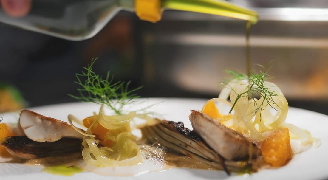 Gourmetgericht mit Fleisch, Zwiebeln, Orangenst&uuml;cken und Kr&auml;utern, &uuml;bergossen mit &Ouml;l