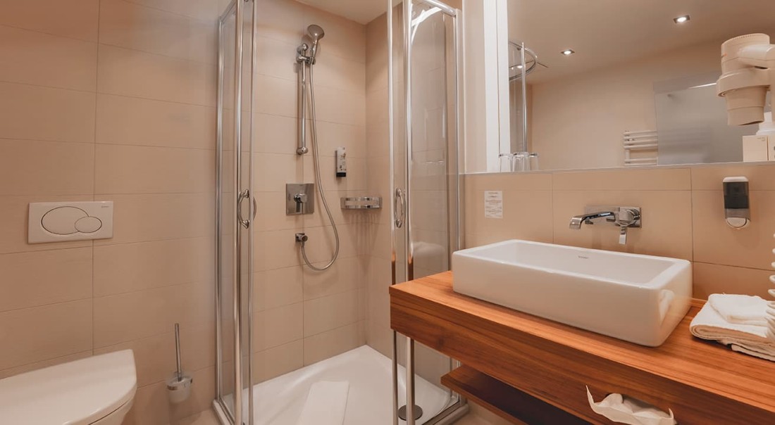 Modernes Badezimmer mit Dusche, Waschbecken und Toilette in neutralen Farben