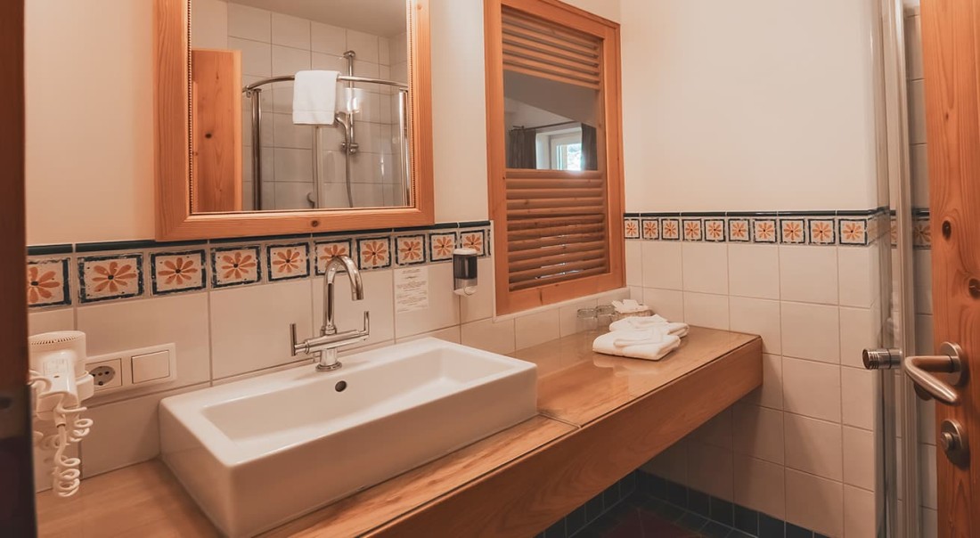 Modernes Badezimmer mit Waschbecken, Spiegel und gefliester Dusche