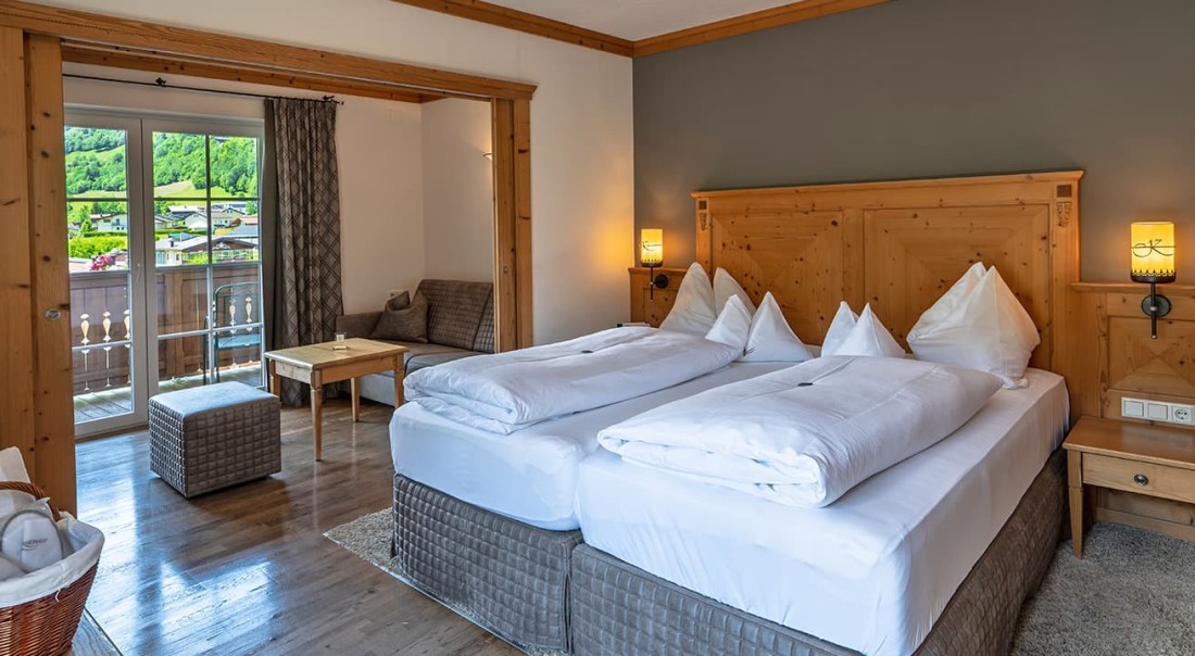 Gem&uuml;tliches Schlafzimmer mit Doppelbett, Balkonblick und rustikalem Holzdekor